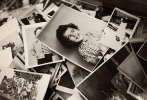 Pile of old black and white photographs including pictures of people portaits