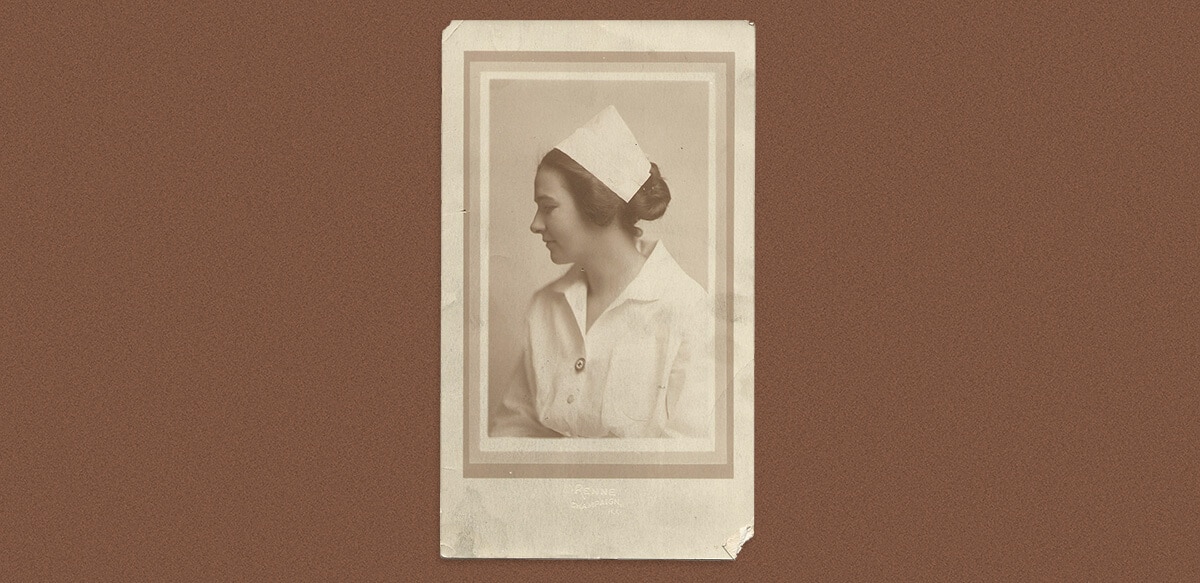 A profile photo of a nurse in a white uniform, with hat, wearing a Red Cross pin