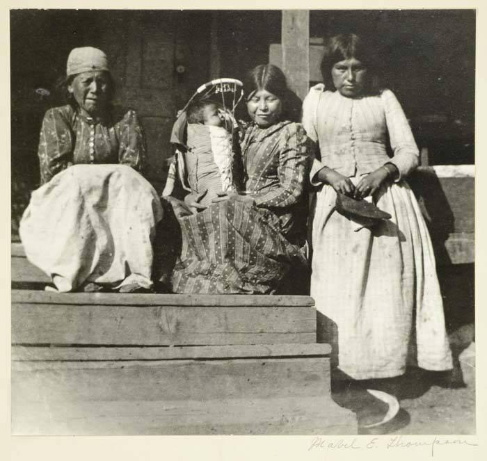 Native American women and infant on porch, circa 1900, Wikimedia Commons