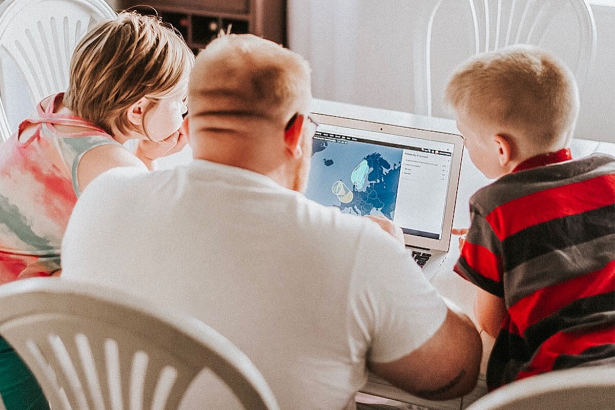 Father reviewing DNA results with children at kitchen table.
