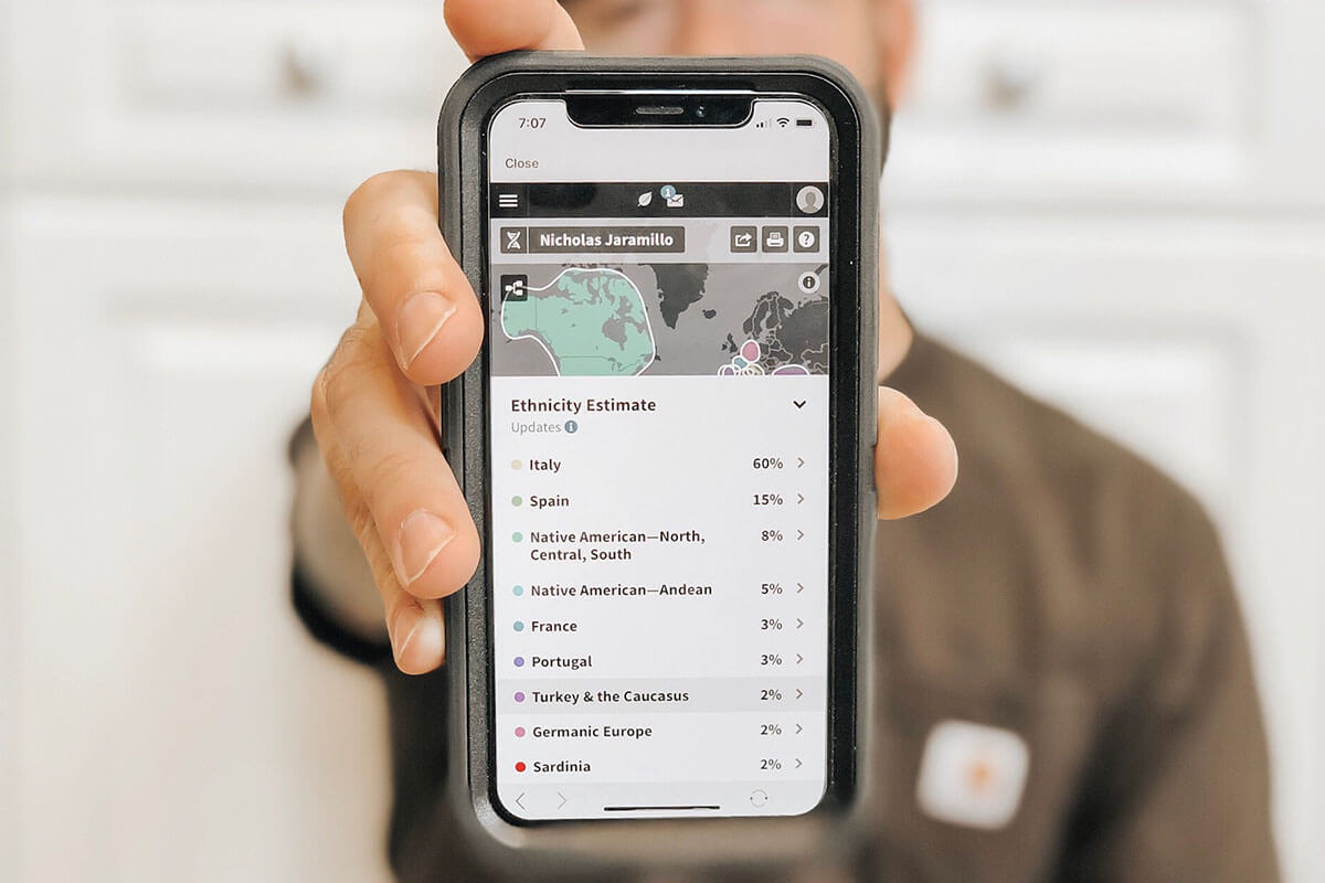 Man holding phone displaying DNA test results.